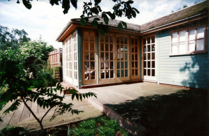 The finished summerhouse and darkroom, showing some of the tiered decking, leading down the garden.