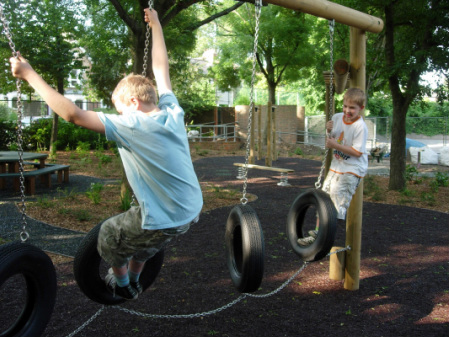 Children playing on the tyre traverse in the Junior play area